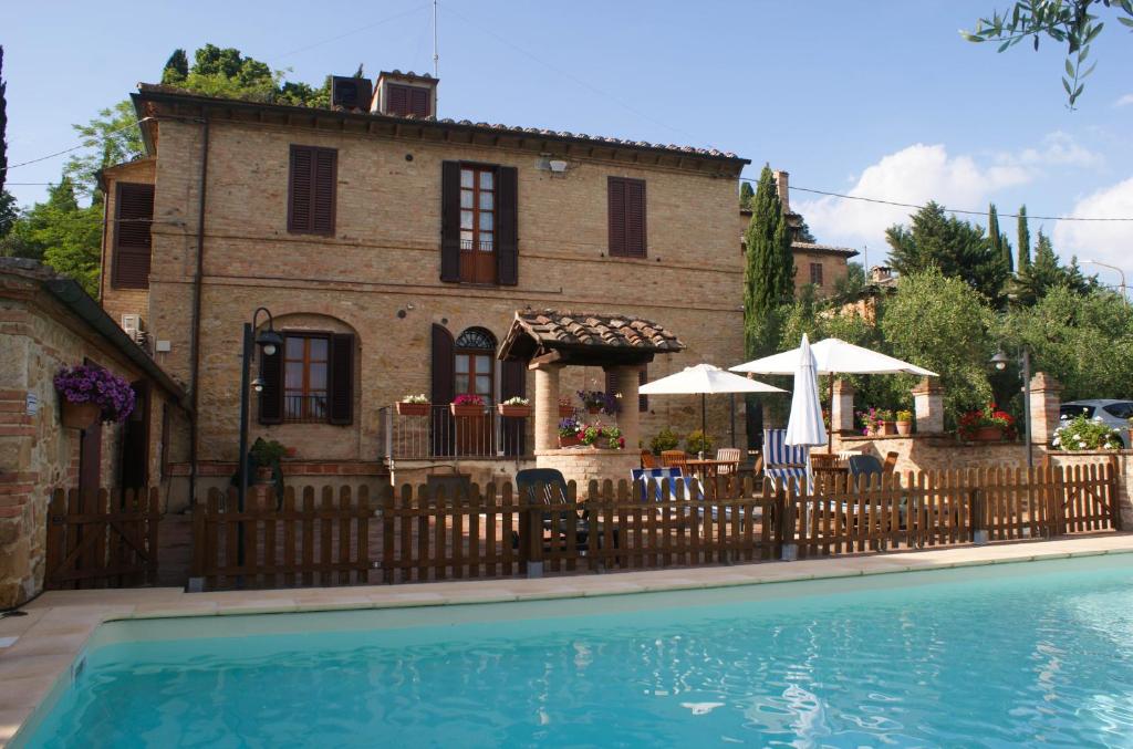 锡耶纳Casa Vacanze L'Oliveta的游泳池旁带围栏的房子