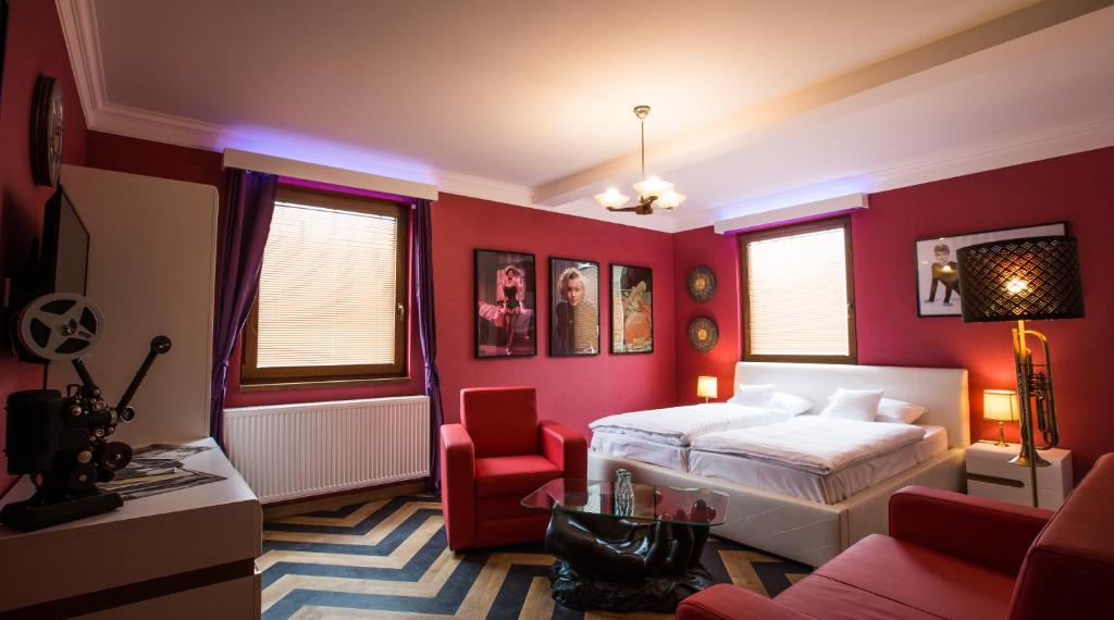 俄斯特拉发Retro hotel Garage的卧室设有红色的墙壁、一张床和椅子