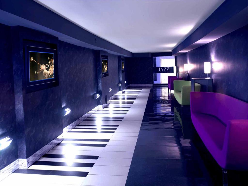佩鲁贾乔威聂伊爵士阿列酒店的餐厅走廊,拥有紫色的墙壁和白色的地板