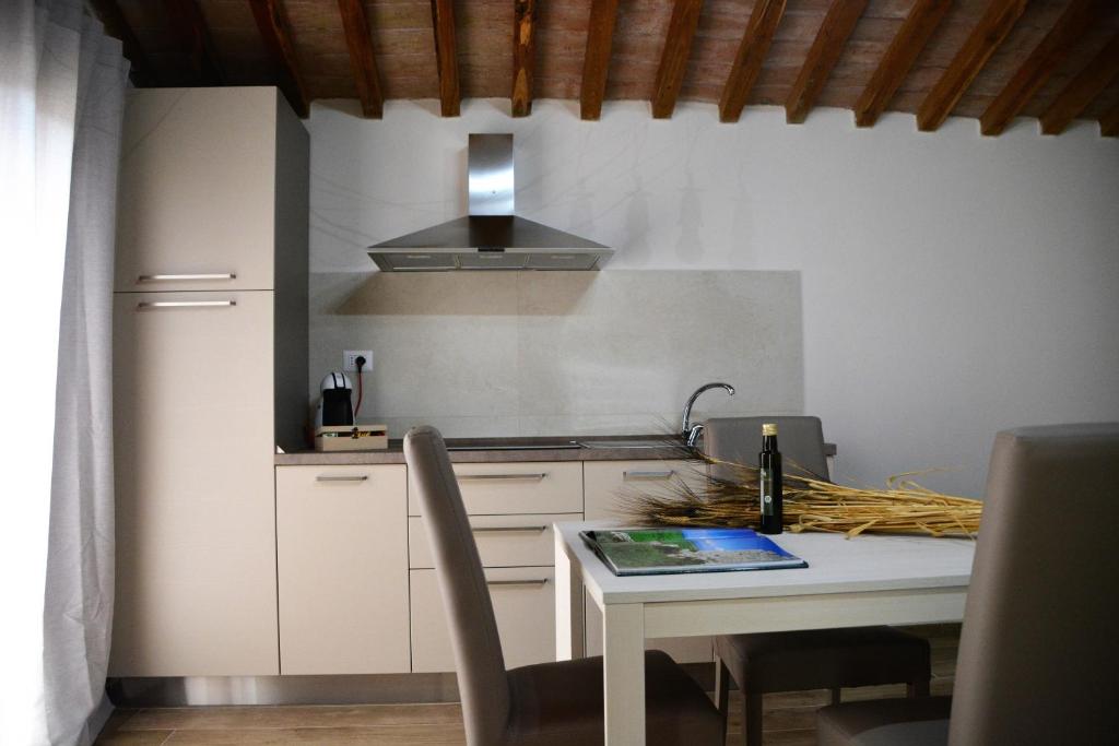 马利亚诺因托斯卡纳Agriturismo L'Aquilone的厨房配有桌子和炉灶。 顶部烤箱