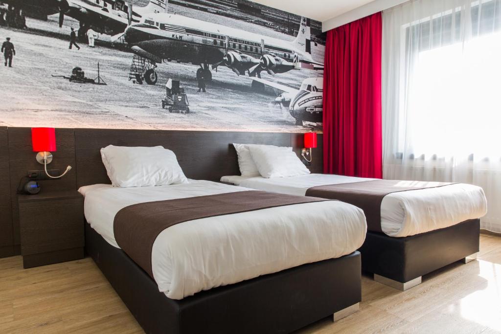 霍夫多普阿姆斯特丹机场贝斯韦斯特优质酒店的配有红色窗帘的酒店客房的两张床
