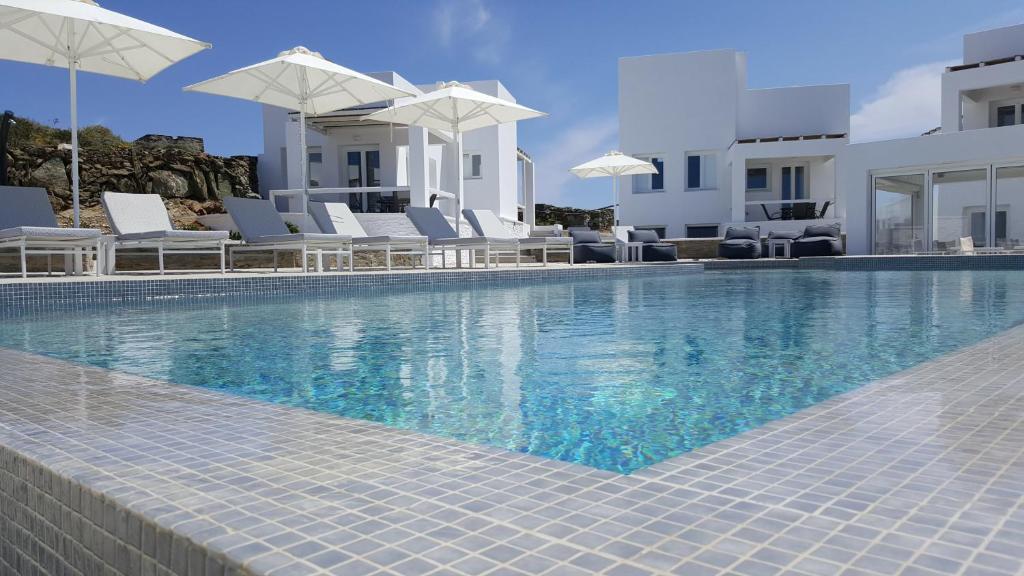Áno Meriá柠檬树度假屋的一个带白色椅子和遮阳伞的游泳池