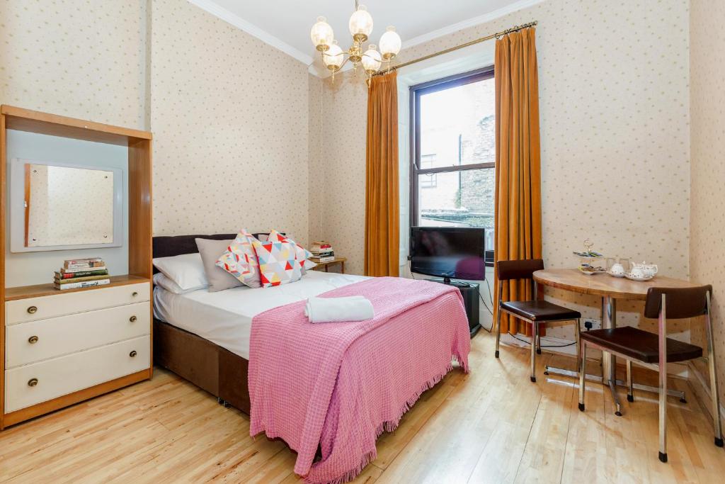伦敦罗素广场酒店的一间卧室配有一张床、一张书桌和一个窗户。