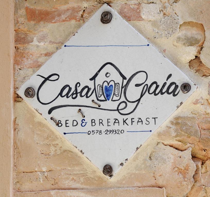 皮耶韦城B&B Casa Gaia的砖墙上的住宿加早餐标志