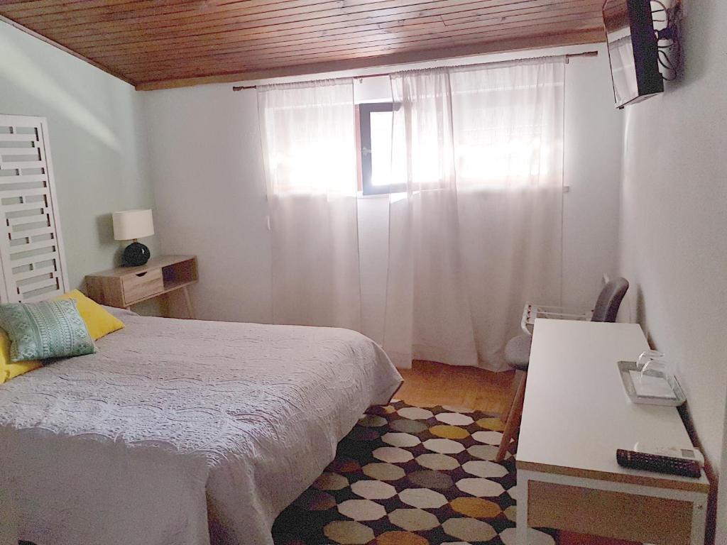 塞图巴尔Casa70的一间卧室设有一张床和一个窗口