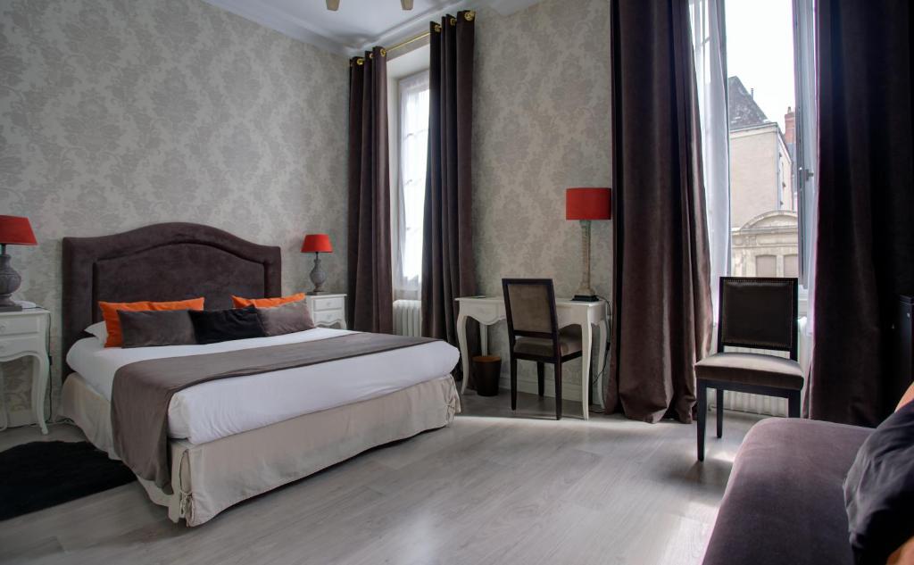 昂热杜梅尔酒店的卧室配有一张床和一张桌子及椅子