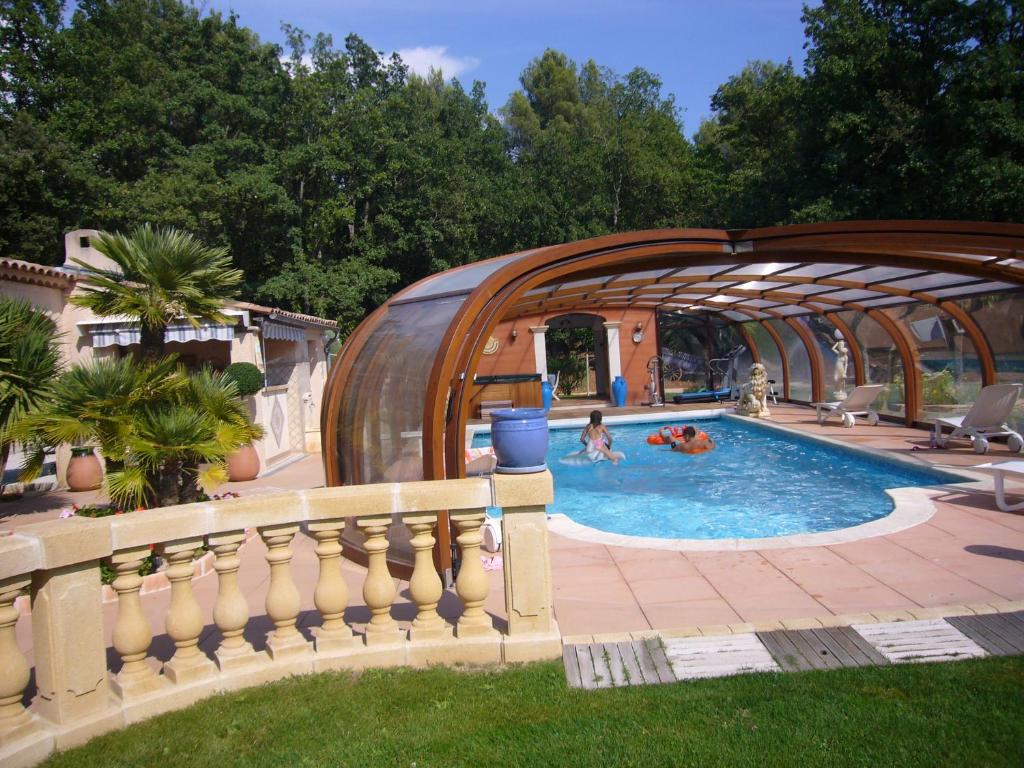 南莱潘Chambre et table d'hôtes Villa Pomponette的一座拥有木制结构的游泳池,里面的人