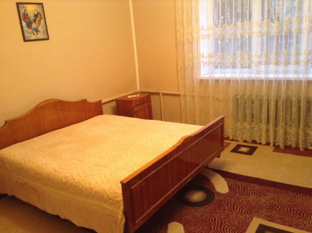 塔塔里夫Вікторія的卧室在窗户前配有一张床