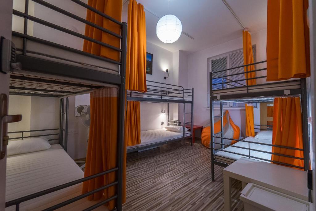 普罗夫迪夫Pijama Hostel的宿舍间设有三张双层床和一张书桌。