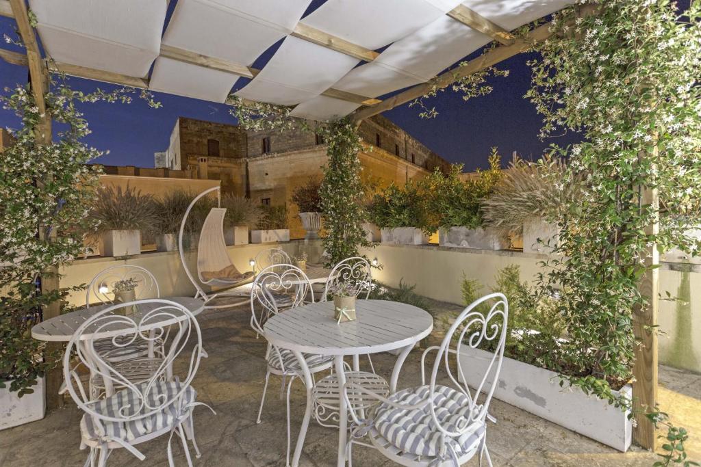 莱切La Loggia dei Raynò的庭院配有桌椅和常春藤