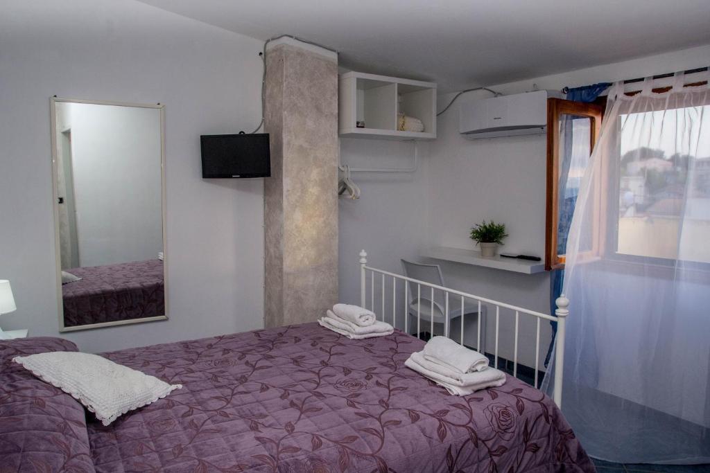 圣尼科拉阿尔切拉B&B Villa San Nicola的一间卧室配有一张床、镜子和窗户