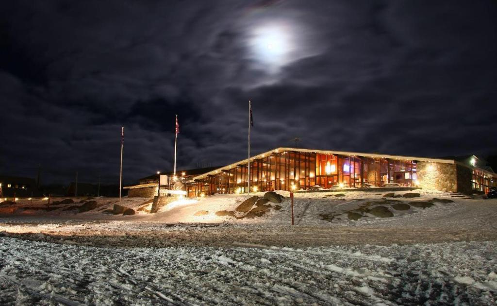 佩里舍峡谷雪河来客酒店的雪中与月亮的建筑物