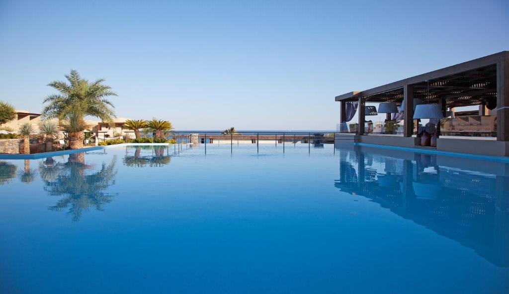 林都斯Aquagrand Exclusive Deluxe Resort Lindos - Adults only的毗邻度假村的大型蓝色海水游泳池