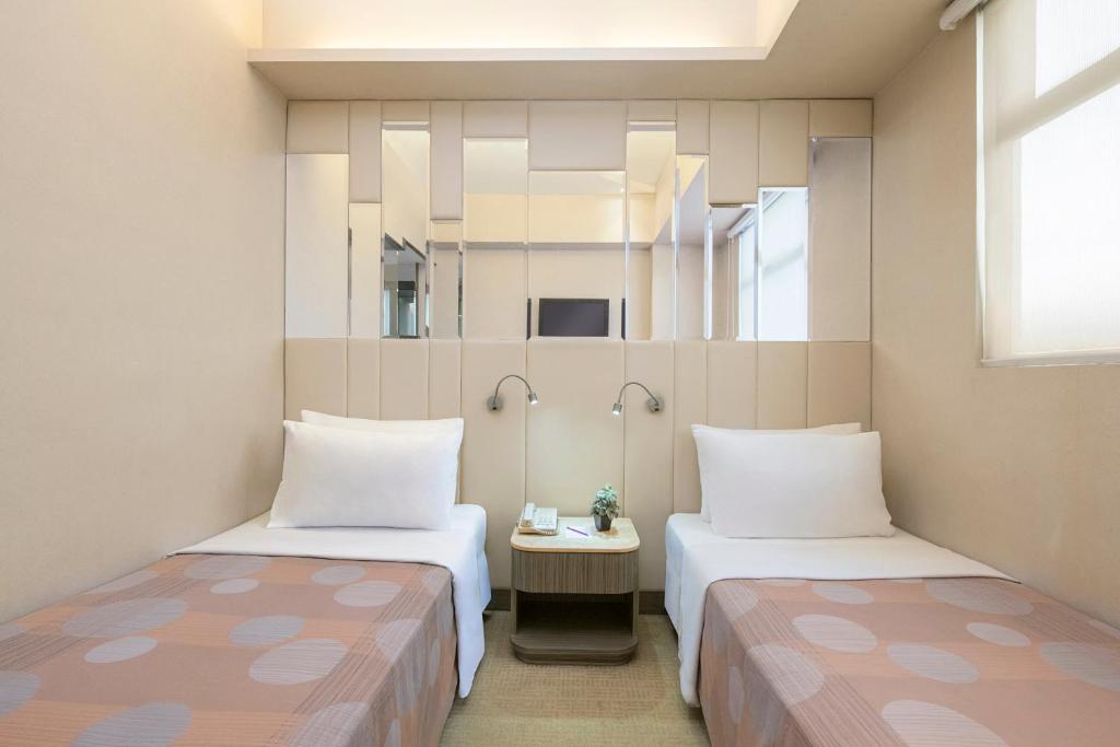 香港香港海景丝丽酒店的带两张床和镜子的客房