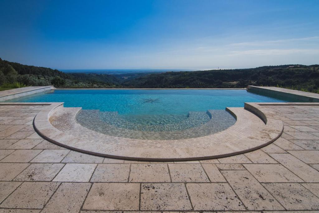 里帕尔贝拉Villa Cava Alta的庭院中间的蓝色海水游泳池