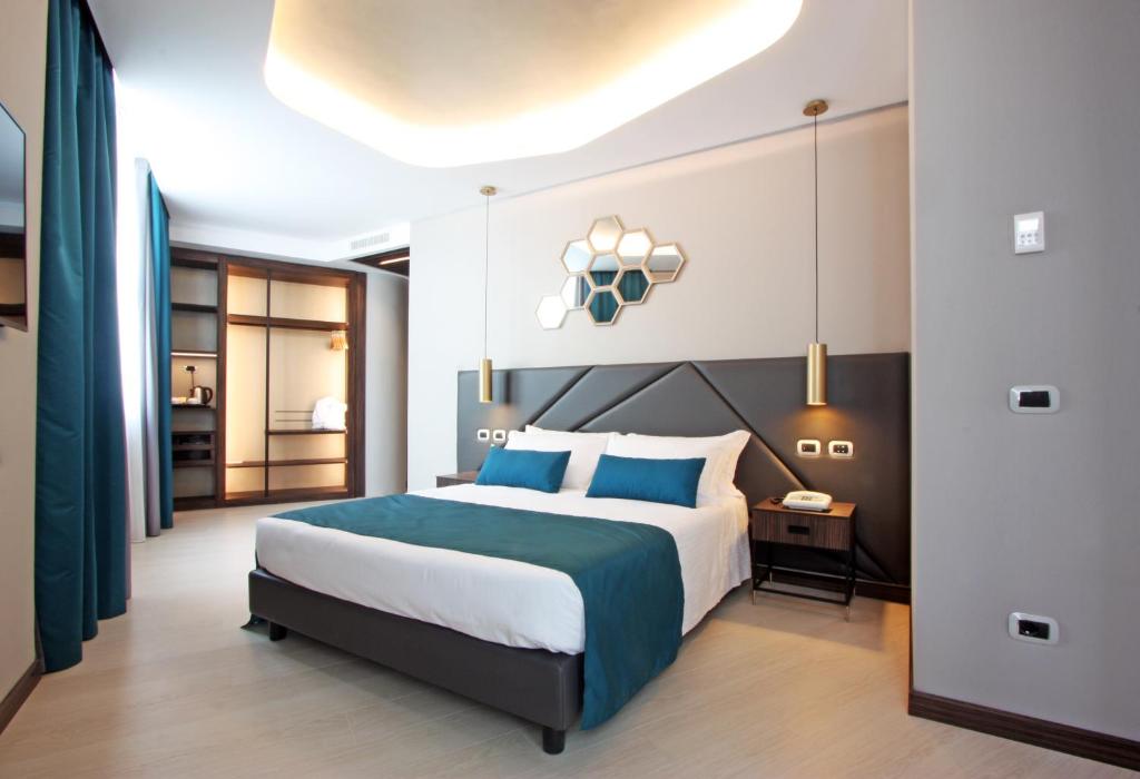 罗马蜂巢酒店的一间卧室配有一张带蓝色枕头的大床