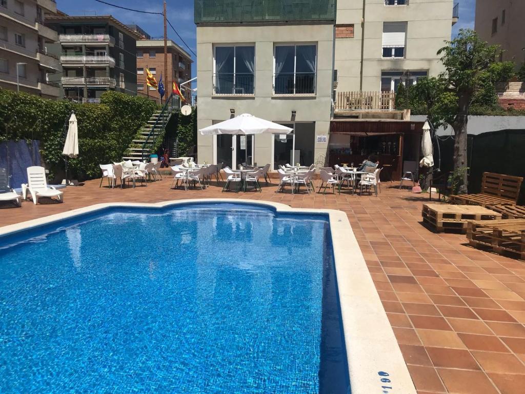 塞古德卡拉斐Hotel Sant Jordi的一座带桌椅的游泳池以及一座建筑