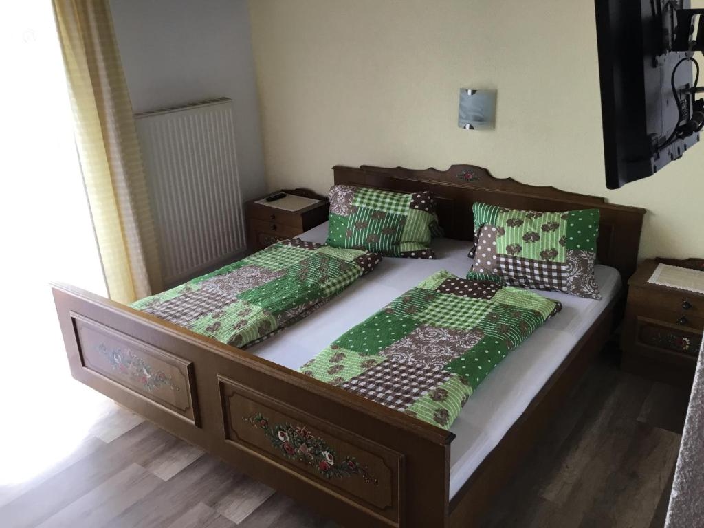 费尔德基兴Gasthof Wadl的卧室内的两张床,配有绿色和白色的棉被