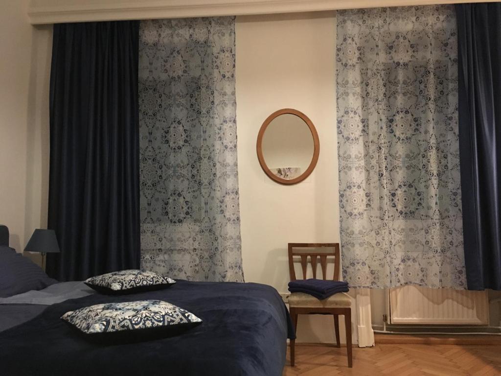 维也纳Apartment Vienna 55的一间卧室配有床、镜子和窗帘