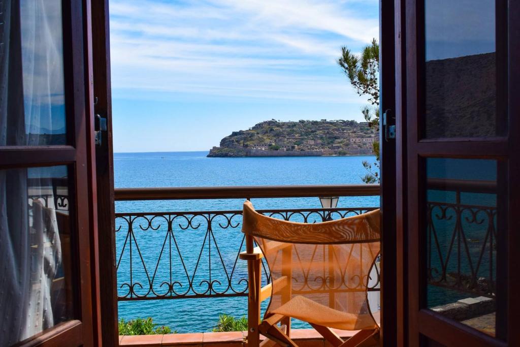 伊罗达The Island sea view apartment的椅子坐在阳台,眺望着大海