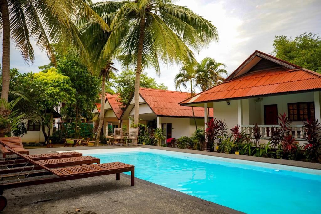 拉迈满月苏梅之家酒店的棕榈树屋前的游泳池