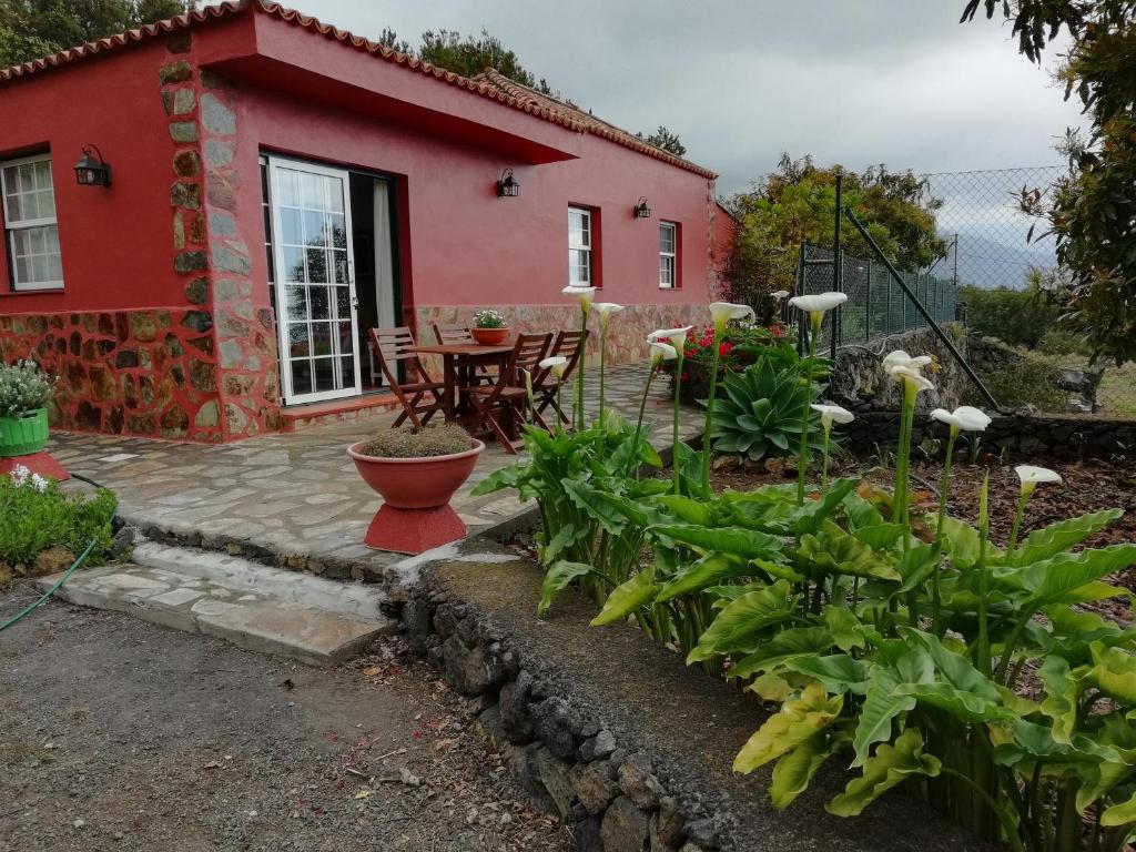 上布雷尼亚Casa Heydi的红色的房子,设有庭院和桌子