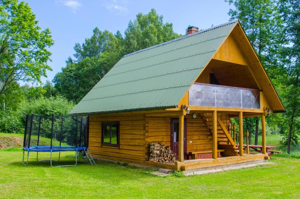 阿格洛纳"Čiekuri"的小木屋设有绿色屋顶和秋千