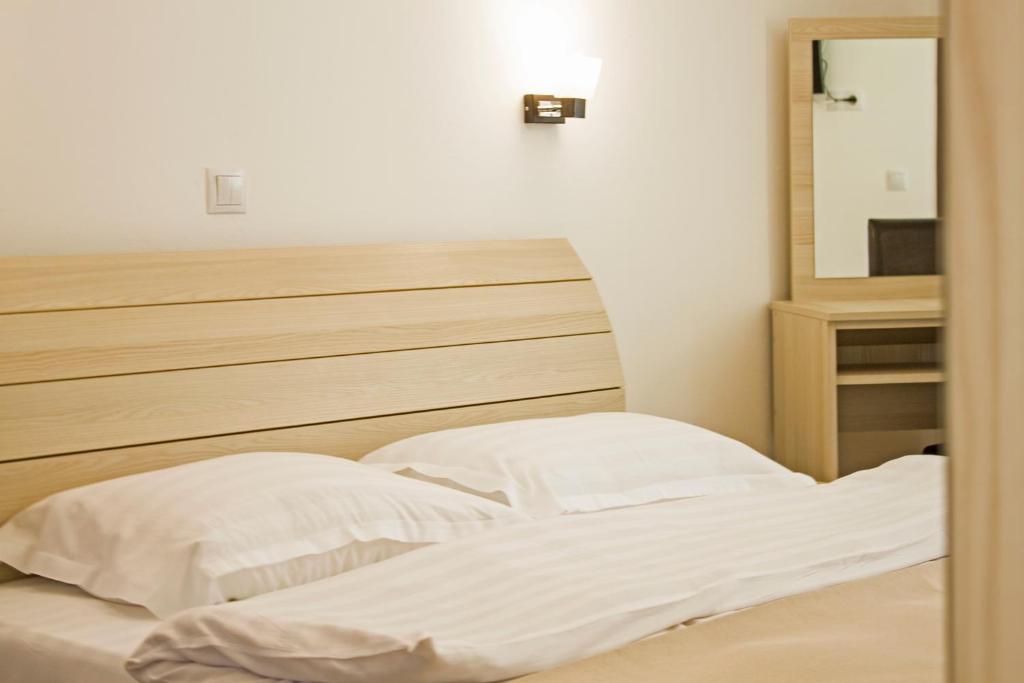西蒙I Love Bran House的一间卧室配有一张带白色床单和镜子的床