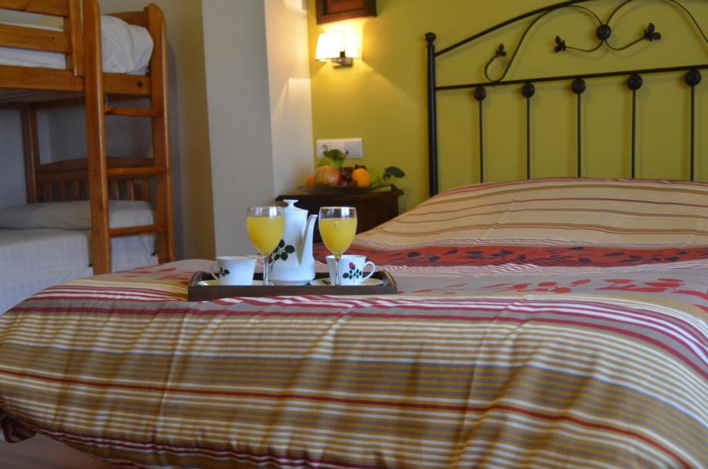 Padul帕杜尔乡村旅馆的一间卧室配有一张带两杯橙汁的床