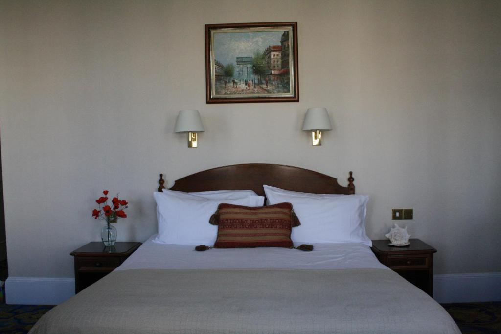 伊斯特布恩威尔明顿广场17号旅馆的一间卧室配有一张带白色枕头的床和两盏灯。