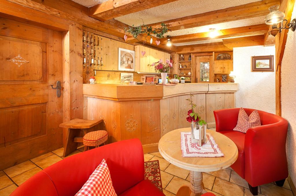 施万高胡伯霍夫兰德酒店的厨房配有红色的椅子、桌子和柜台