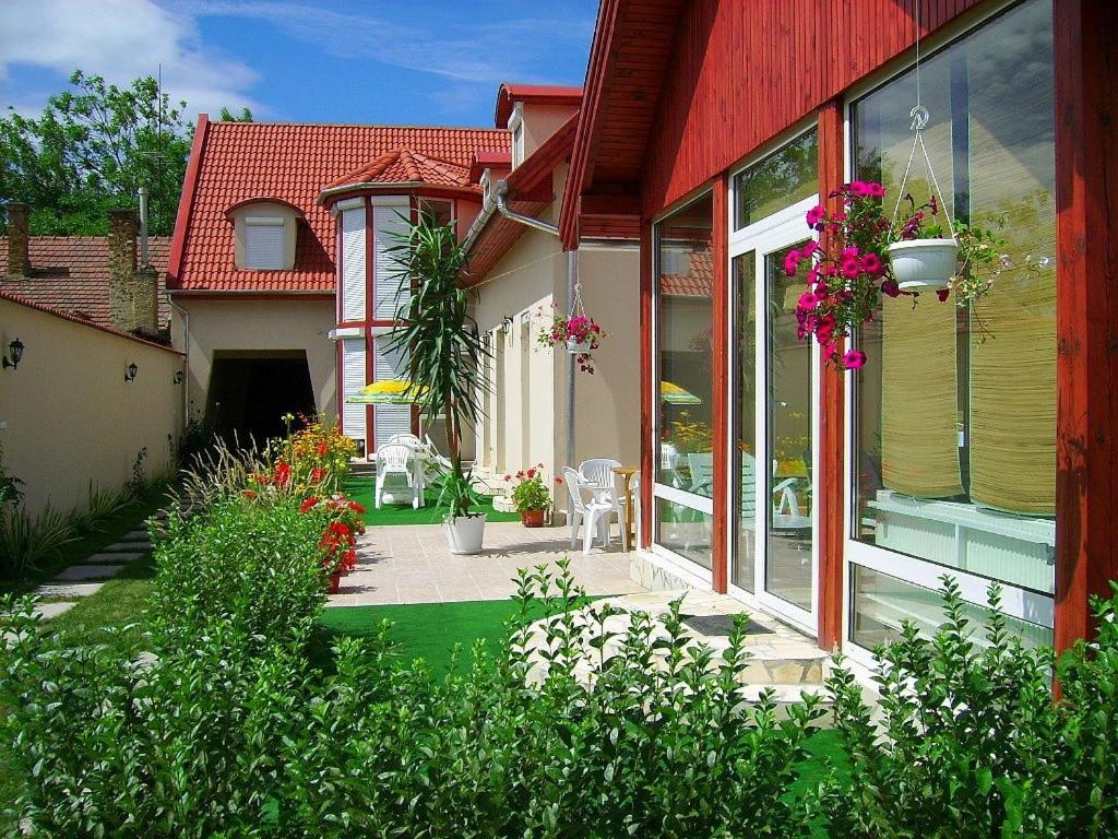 埃格尔阿格瑞亚健康旅馆的一座红色屋顶的房子和一个鲜花庭院