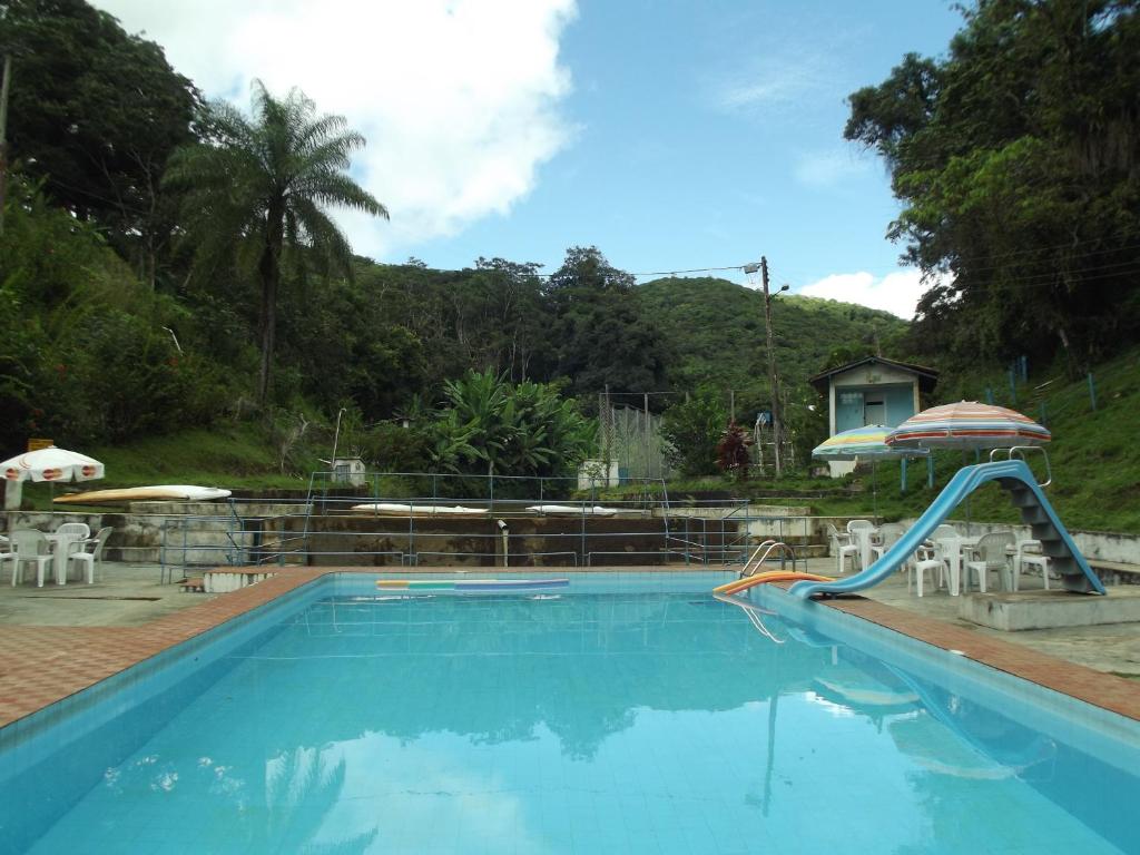 帕科蒂Estancia Vale das Flores的度假村内带滑梯的游泳池