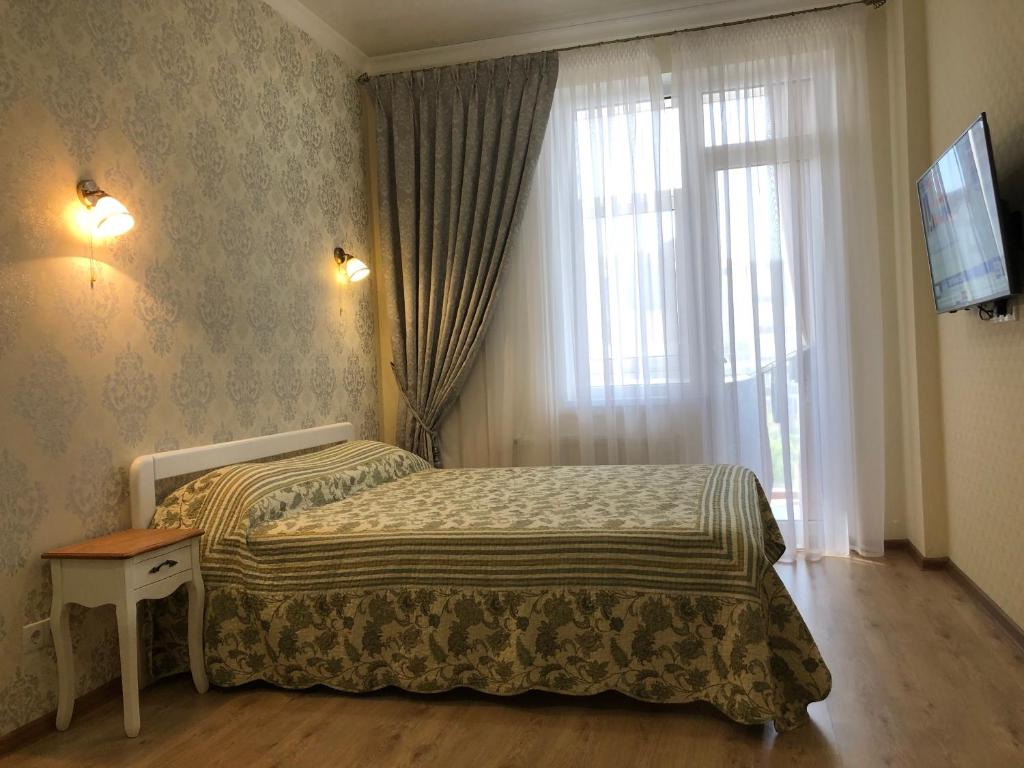 克里扎尼夫卡Morskaya zhemchuzhina na Marselskoy的卧室在窗户前配有一张床