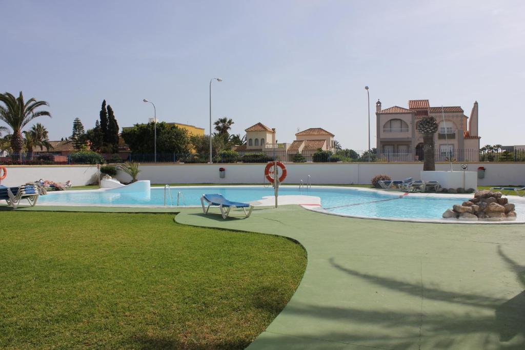 滨海罗克塔斯Apartamentos El Minarete的一个带长凳的大型游泳池