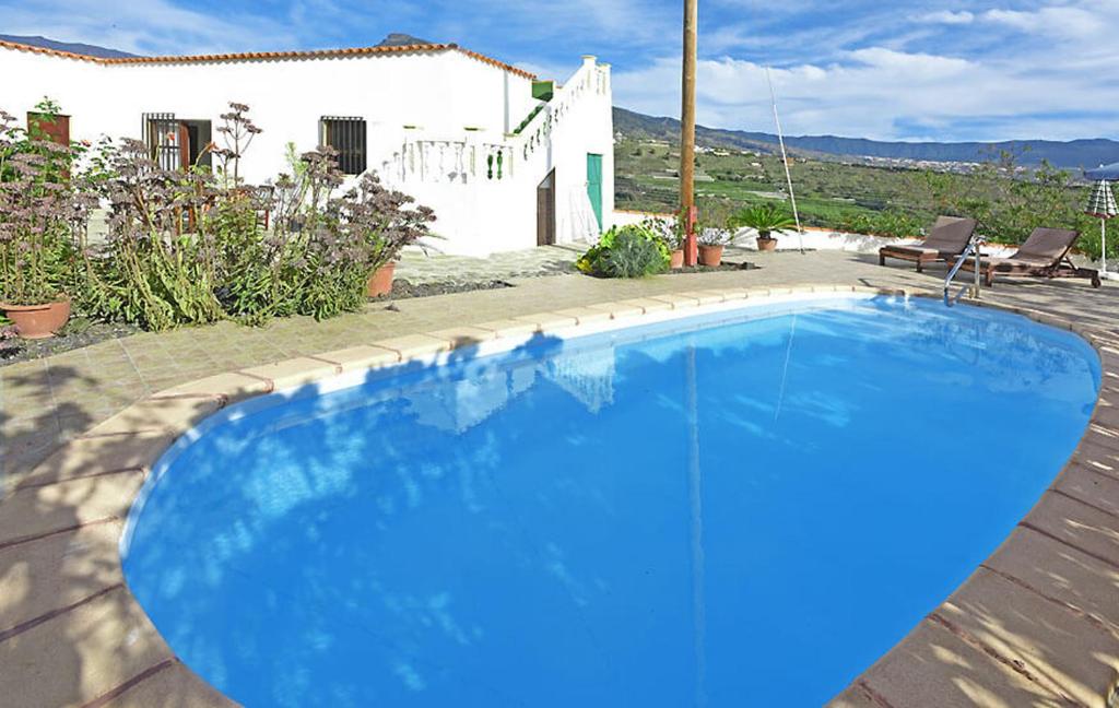蒂哈拉费Casa Amagar的房子前面的蓝色游泳池