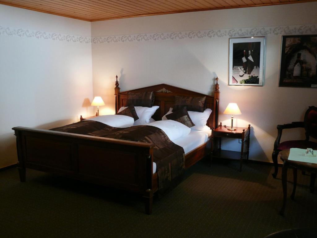 Osthofen维本罗斯葡萄酒旅馆的一间卧室配有一张大床和两盏灯。