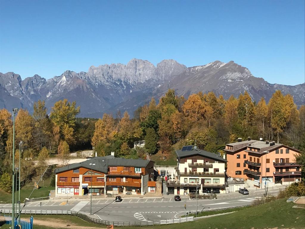 贝卢诺Albergo Slalom的一座建筑,后面设有停车场,后面是群山
