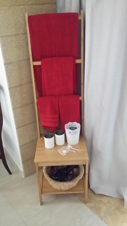 卡斯泰拉内塔a Cast B&B的一张带红色靠垫的椅子和一张桌子上的两个碗