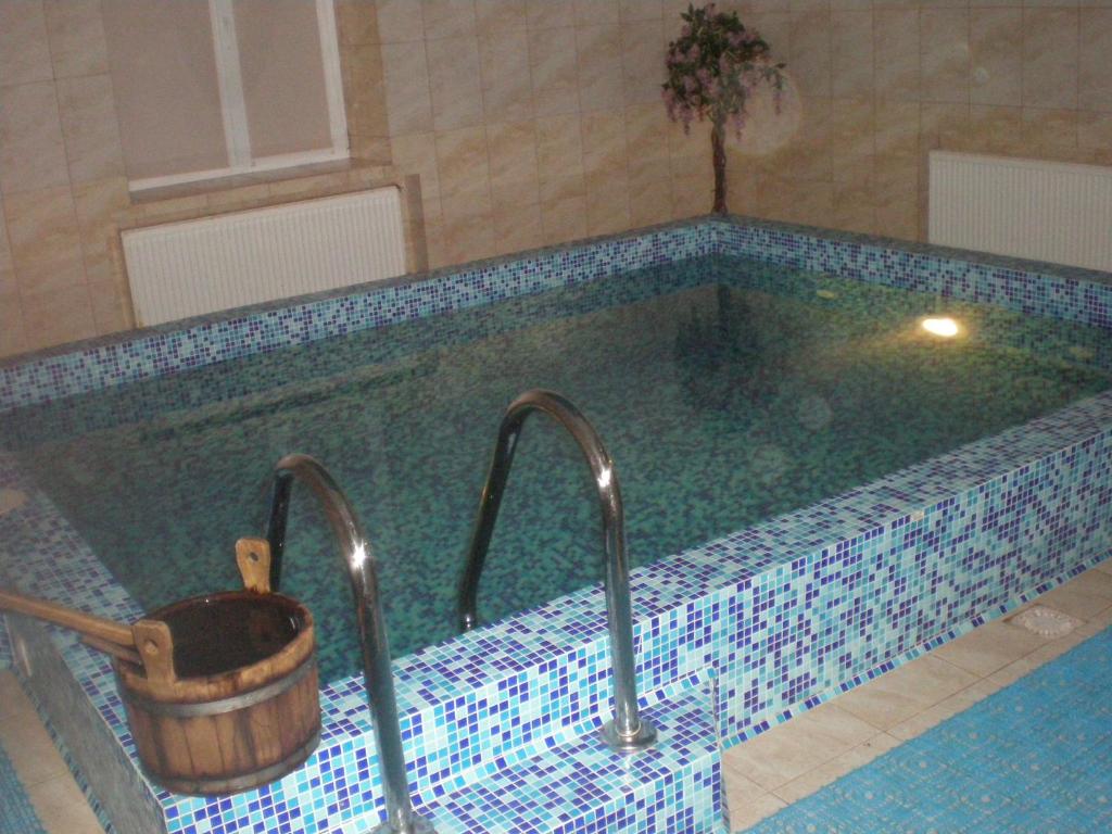 Nyzhni MlynyГотельно- банний комплекс Афродіта的一个带两个水龙头和水桶的游泳池