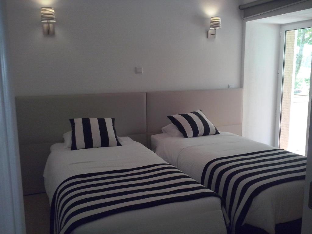 法蒂玛Nas Palhas Deitado的客房内的两张床和条纹床单