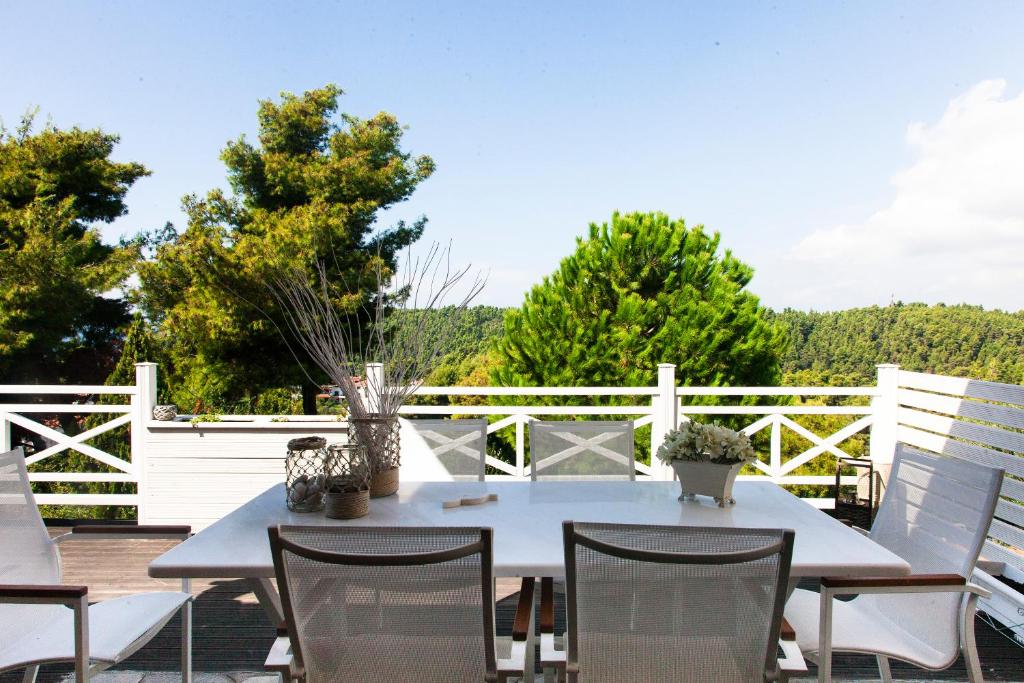 希维利Elani Beautiful Villa的庭院配有桌椅和白色围栏