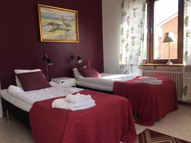 耶利瓦勒Pensionat Augustin的酒店客房,配有两张带红色床单的床