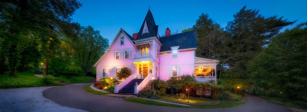 阿什维尔Cedar Crest Inn的一座带灯的大粉色房子
