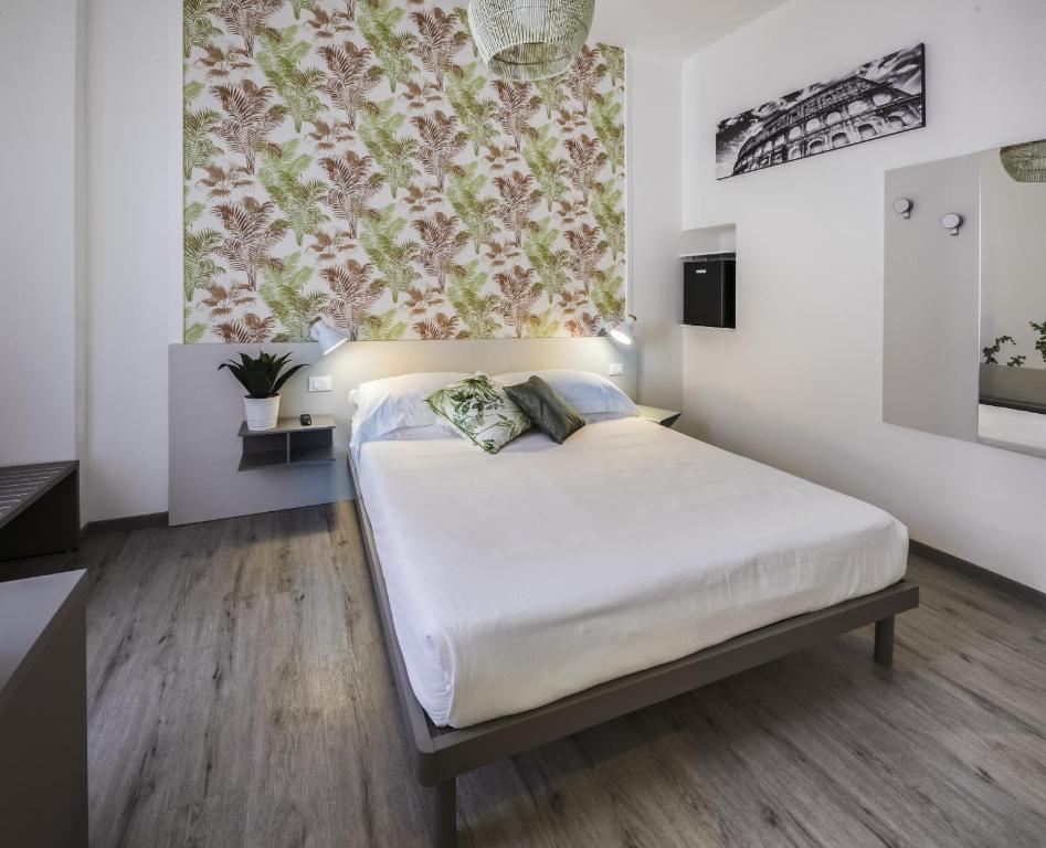 罗马Lele Rooms San Lorenzo的一间卧室配有白色床单和花卉窗帘
