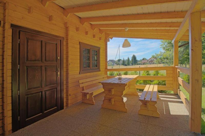 JunoszynoDomki na 102的小木屋的门廊,配有长凳和门