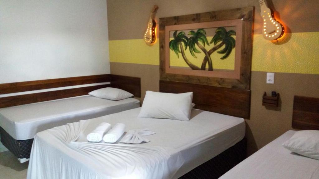 诺布里斯Pousada Rota das Águas的客房内的两张床和白色毛巾