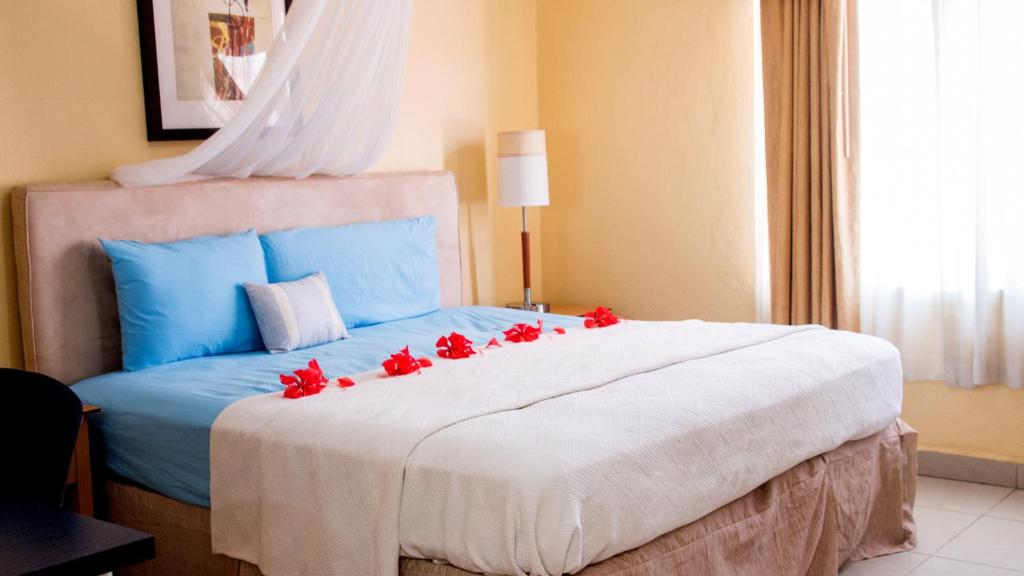 弗里敦The Jam Lodge的一间卧室配有一张红色鲜花的大床