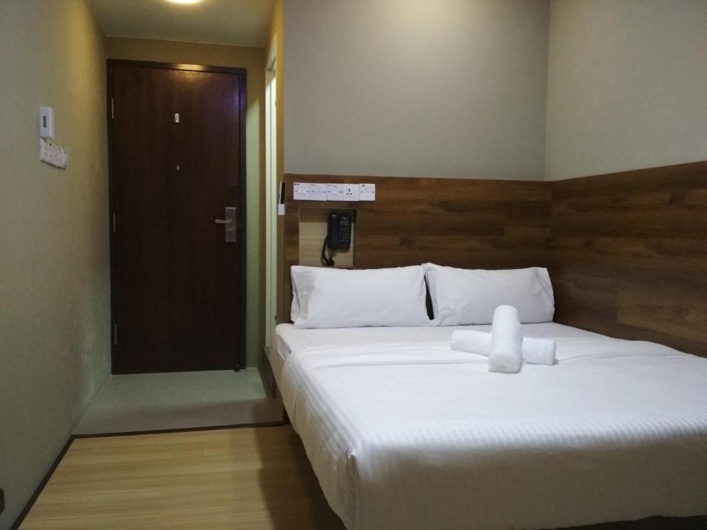 斯里巴加湾市Qing Yun Rest House Gadong, Brunei Darussalam的卧室配有一张白色的大床和一扇门