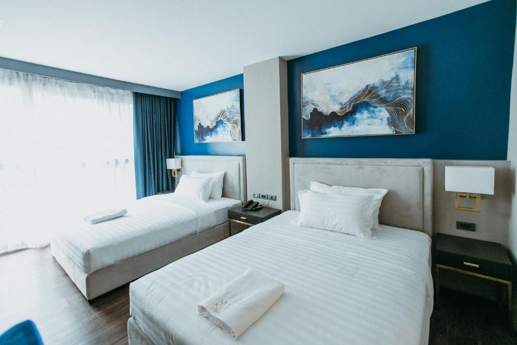 杜马格特PVL套房酒店的两张位于酒店客房的床,拥有蓝色的墙壁